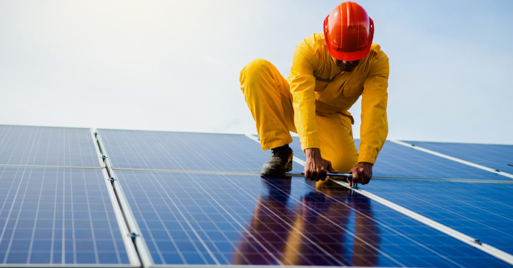 Image of man working on solar panel.