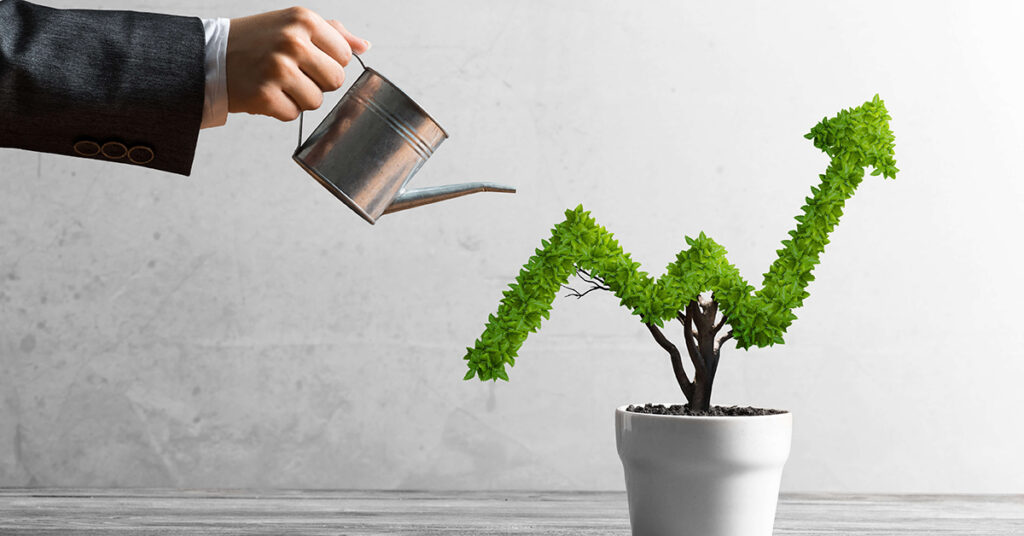 Image of business man watering plant shaped like an upward trend on a line graph