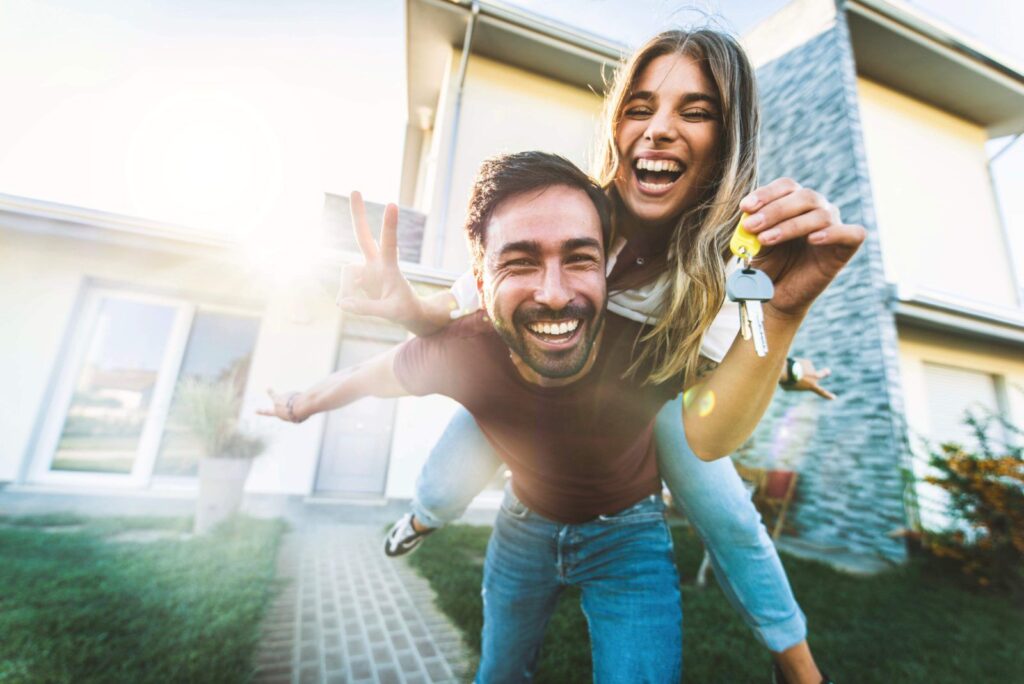 Can renters switch electricity providers? Photo of a smiling couple in front of their new home.