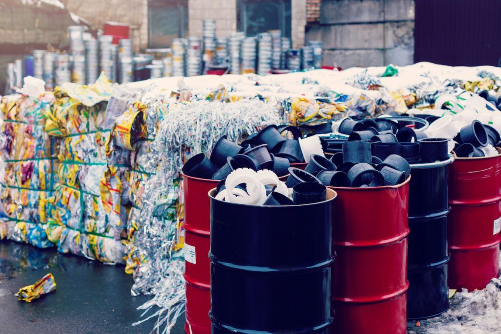 Tips to reduce your business waste. Photo of recycled materials stacked up for removal.