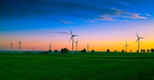 Clean Energy milestones achieved in the U.S. Photo of windmill turbines in a field along the backdrop of sun set.